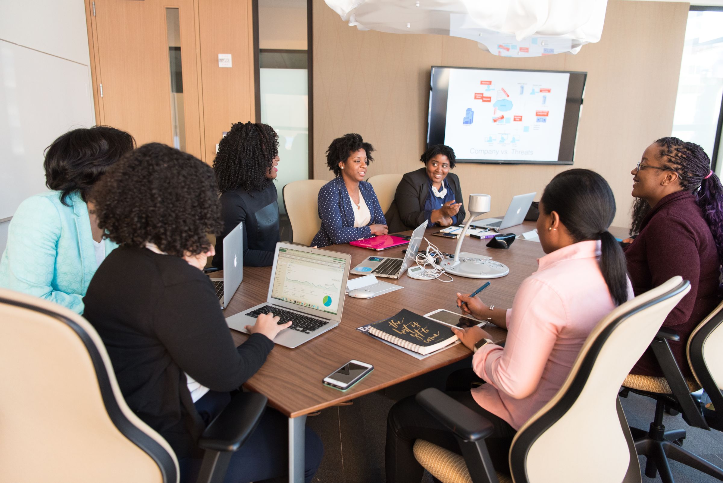 Employees discussing workplace technology guidance around a laptop